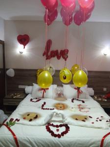 Cette chambre comprend un lit avec des ballons et des cœurs. dans l'établissement HOTEL BORJ SAFAE LAAYOUNE, à Laâyoune