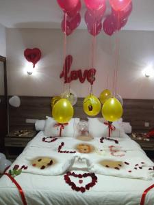 um quarto com uma cama com balões e corações em HOTEL BORJ SAFAE LAAYOUNE em Laayoune