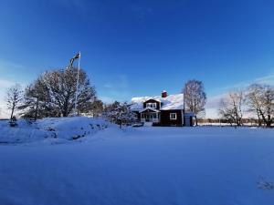une maison dans la neige avec un drapeau sur elle dans l'établissement Äppelgården, à Sollebrunn