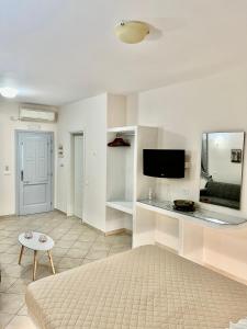 un soggiorno con letto e TV a schermo piatto di Artemisia Apartment Caldera a Imerovigli