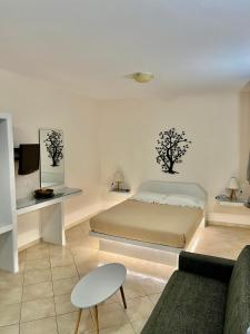 ein weißes Schlafzimmer mit einem Bett und einem Sofa in der Unterkunft Artemisia Apartment Caldera in Imerovigli