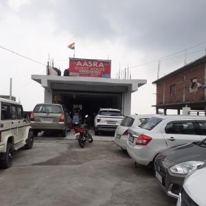 a parking lot with cars parked in front of a garage at Hotel aasra guest house in Bharwain
