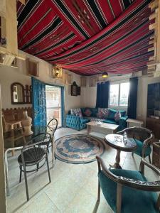 Una sala de estar con un sofá, mesas y sillas. en Antica old apartment al-lwebdeh, en Amán