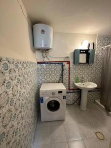 a bathroom with a washing machine and a sink at Antica old apartment al-lwebdeh in Amman