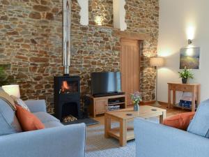 a living room with a fireplace and a tv at The Horse Gin - Uk11024 in East Worlington