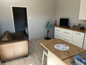 a kitchen with a couch and a table in a room at Zen Stone Guest House in Postmasburg
