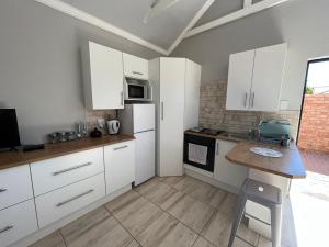 a kitchen with white cabinets and a counter top at Zen Stone Guest House in Postmasburg