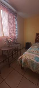 a bedroom with a bed and a table and window at HOSPEDAJE 4Casa San Francisco in Zacatlán