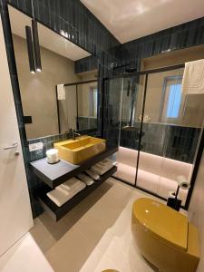 a bathroom with a yellow sink and a toilet at Archimar House in Taranto