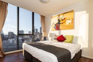 a bedroom with a large bed with a large window at Jade Resorts Melbourne in Melbourne
