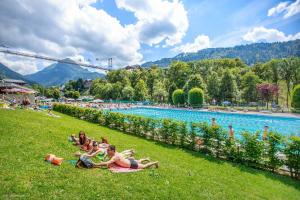 a group of people laying on the grass by a pool at Edelweiss in Morzine