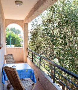 een tafel en stoelen op een balkon met een boom bij Motel Cap Sol in Mandelieu-la-Napoule