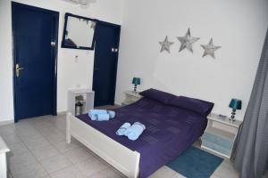 - une chambre avec un lit violet et des serviettes dans l'établissement Relaxing and Comfortable Studio Near Falasarna Beaches, à Plátanos