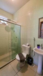 uma casa de banho com um chuveiro, um WC e um lavatório. em Casa Sabiá - Lençóis/BA em Lençóis