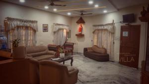 a large living room with couches and a tv at Metropolitan Serviced Villa in Cochin