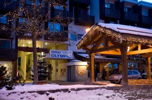 une rue de la ville avec des lumières de Noël et un bâtiment dans l'établissement Madame Vacances - Hôtel Courchevel Olympic, à Courchevel