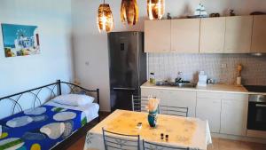 een kleine keuken met een tafel en een bed in een kamer bij Seaside Residence Kiki Prassa,Kimolos in Kimolos