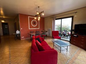 sala de estar con sofá rojo y mesa en Les Vignes en Pomport