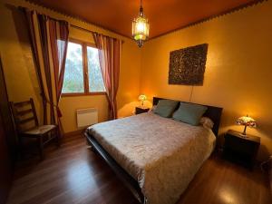 een slaapkamer met een bed, een stoel en een raam bij Les Vignes in Pomport