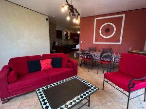 un soggiorno con tavolo e divano rossi di Les Vignes a Pomport