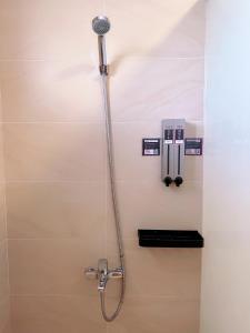 y baño con ducha y cabezal de ducha. en Happy Fat B&B 寵物友善 en Taitung