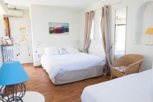 um quarto com 2 camas e um candeeiro azul em Motel Cap Sol em Mandelieu-la-Napoule