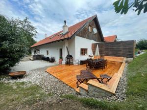 una casa con una terraza de madera frente a ella en wundervoll eben - CHALETS & PLÄTZE voller WUNDER - NOTSCHKERL & FEINIS en Waasen