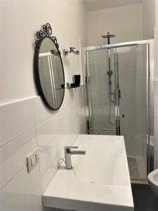 a white bathroom with a sink and a mirror at Mega House in Catania