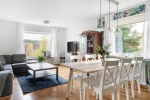 a dining room and living room with a table and chairs at Peaceful holiday home surrounded by nature in Töllsjö