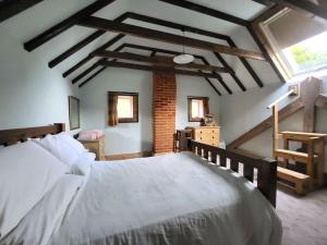 a bedroom with a large white bed in a room at The Old Dairy in rural sea side location in Norwich