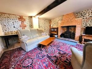 a living room with a couch and a fireplace at The Old Dairy in rural sea side location in Norwich