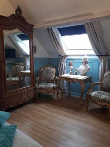 um quarto com duas cadeiras, uma mesa e um espelho em La Perle Secrète em Theneuille
