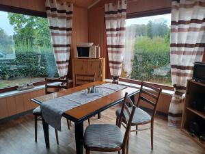 a dining room with a table and chairs and a large window at Pension Pawlak in Tauche