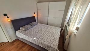 a small bed in a small bedroom with a window at Apartman Noa in Jušići
