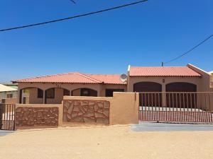 a house with a fence in front of it at JJP SELF CATERING - Three bedroom house in Lüderitz
