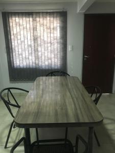 una mesa de madera y sillas en una habitación con ventana en DEPARTAMENTO CABRERA en Mendoza