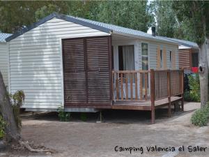 a large wooden cabin with a porch and a deck at Camping Valencia el Saler in El Saler