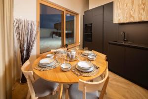 una cocina con una mesa de madera con platos y vasos. en Bird's eye view, Hillside, en Dolný Kubín
