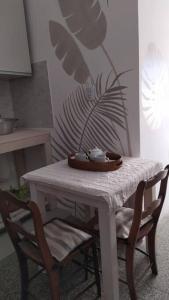 una mesa blanca con dos sillas y un plato en ella en eco veggie en Esperanza
