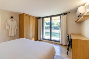 1 dormitorio con 1 cama, vestidor y ventana en Mougins Collection - Ravissante Suite avec Bassin chauffé en saison, en Mougins