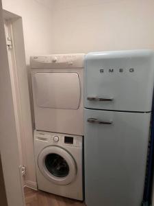 uma lavandaria com uma máquina de lavar roupa e uma máquina de lavar roupa em Beautiful 1 bed bungalow em Ryde
