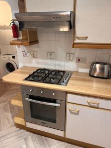 uma cozinha com uma placa de fogão e forno. em Beautiful 1 bed bungalow em Ryde