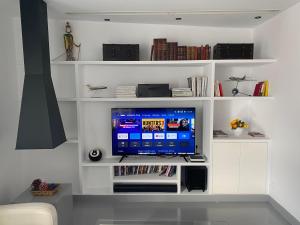 a living room with a flat screen tv on white shelves at Apartamento en Madrid Rio con Parking Gratuito in Madrid