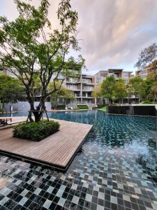 a pool with a tree next to a building at Hill & Valley Khaoyai by Nancy in Ban Huai Sok Noi