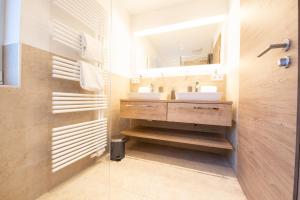 a bathroom with two sinks and a mirror at Haus Kreuzbichl in Grainau