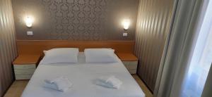 ein Schlafzimmer mit einem Bett mit zwei Hausschuhen darauf in der Unterkunft Hotel Nuovo Rondò in Sesto San Giovanni