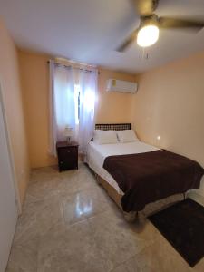 1 dormitorio con 1 cama y ventilador de techo en Kaylavill, en Nassau