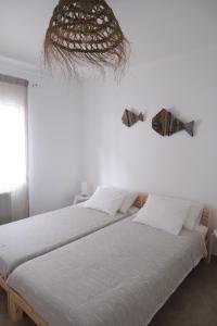 dos camas sentadas una al lado de la otra en una habitación en Oliveira Beach House, en Longueira