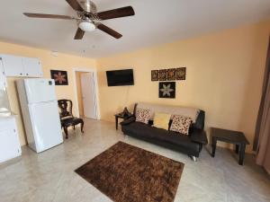 sala de estar con sofá y ventilador de techo en Kaylavill, en Nassau