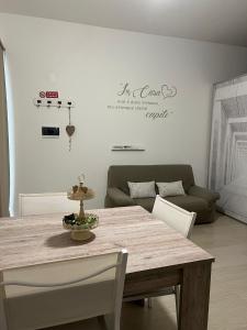 una sala da pranzo con un tavolo e un divano di Casa Nicola Maria a Grottaglie